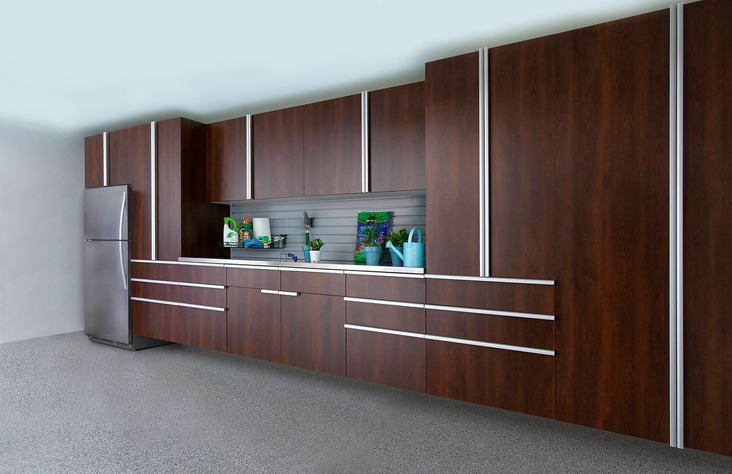 Modern kitchen with dark wood cabinets, stainless steel refrigerator, and white countertops.
