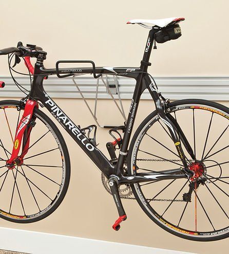 Black Pinarello road bike mounted on a wall-mounted rack.