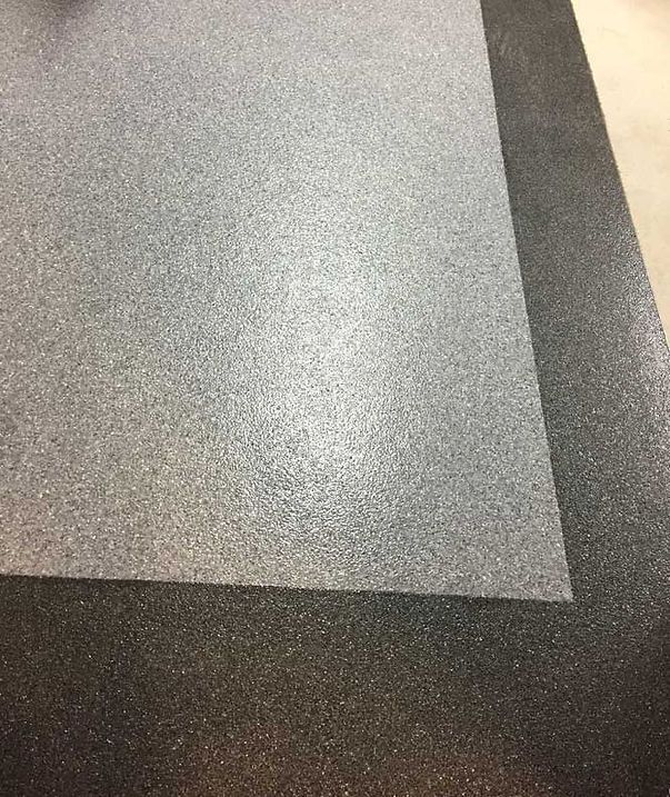 Two sheets of textured, gray and black material, possibly flooring or mats.