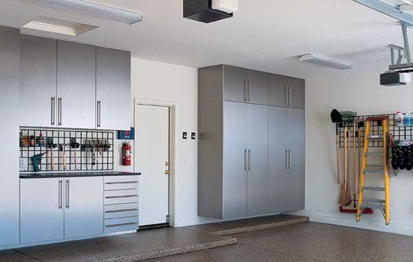 Garage interior with metal storage cabinets, tools, and a ladder.