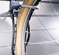 Bike wheel hanging on a storage hook attached to a slotted wall.