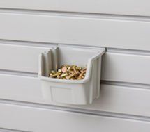Gray plastic storage bin on a wall filled with small, golden items.