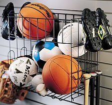 Black wire sports equipment organizer holding balls, cleats, baseball glove, and bat.
