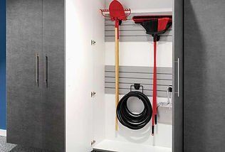 Garage cabinet with cleaning supplies: broom, rake, hose. Gray and white interior.