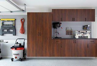 Garage with wooden cabinets, tools, and a shop vacuum.