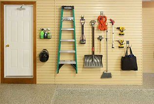 Garage wall with tools and equipment neatly organized on a slatted panel.