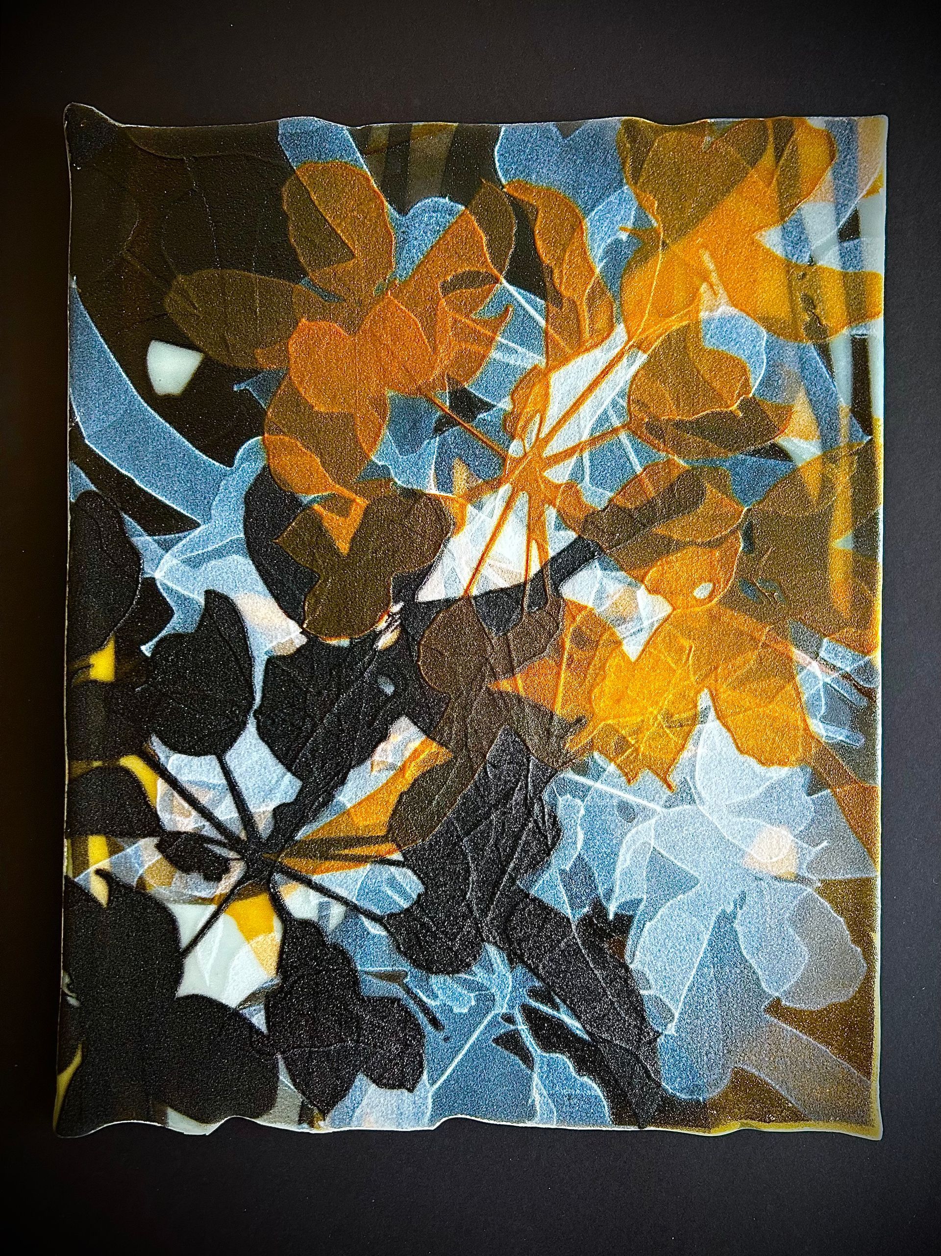 A painting of leaves on a black background