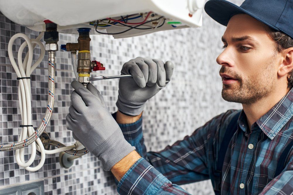 Worker Set Up Electric Heating Boiler At Home — Dempsey Plumbing In Cooranbong