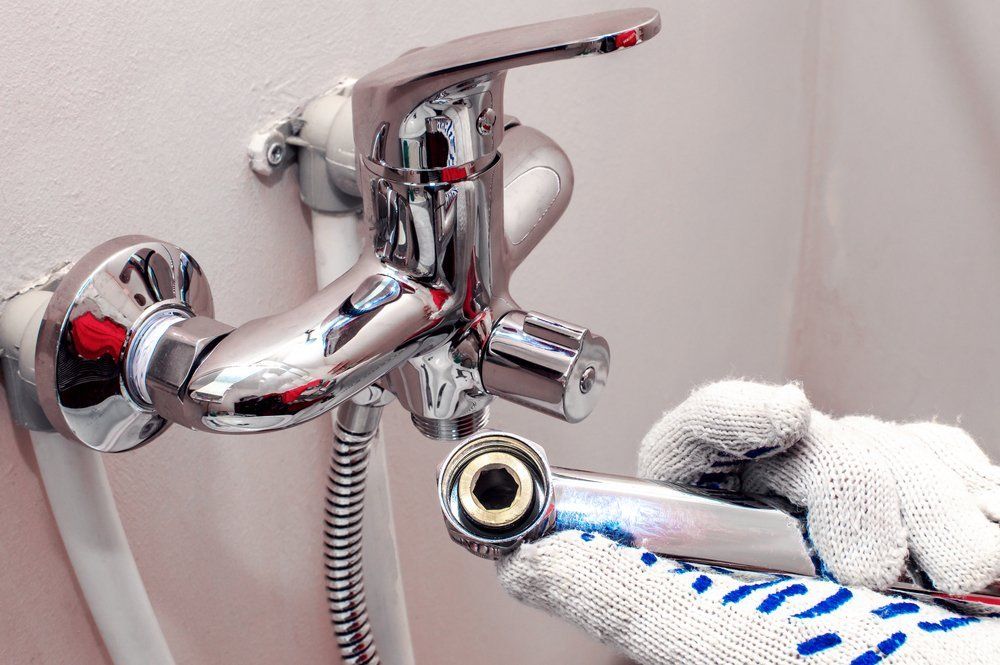 Men's Hands In Gloves Are Fixing Bath Tap — Dempsey Plumbing In Erina