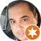 Um close do rosto de um homem em um círculo com uma estrela laranja.