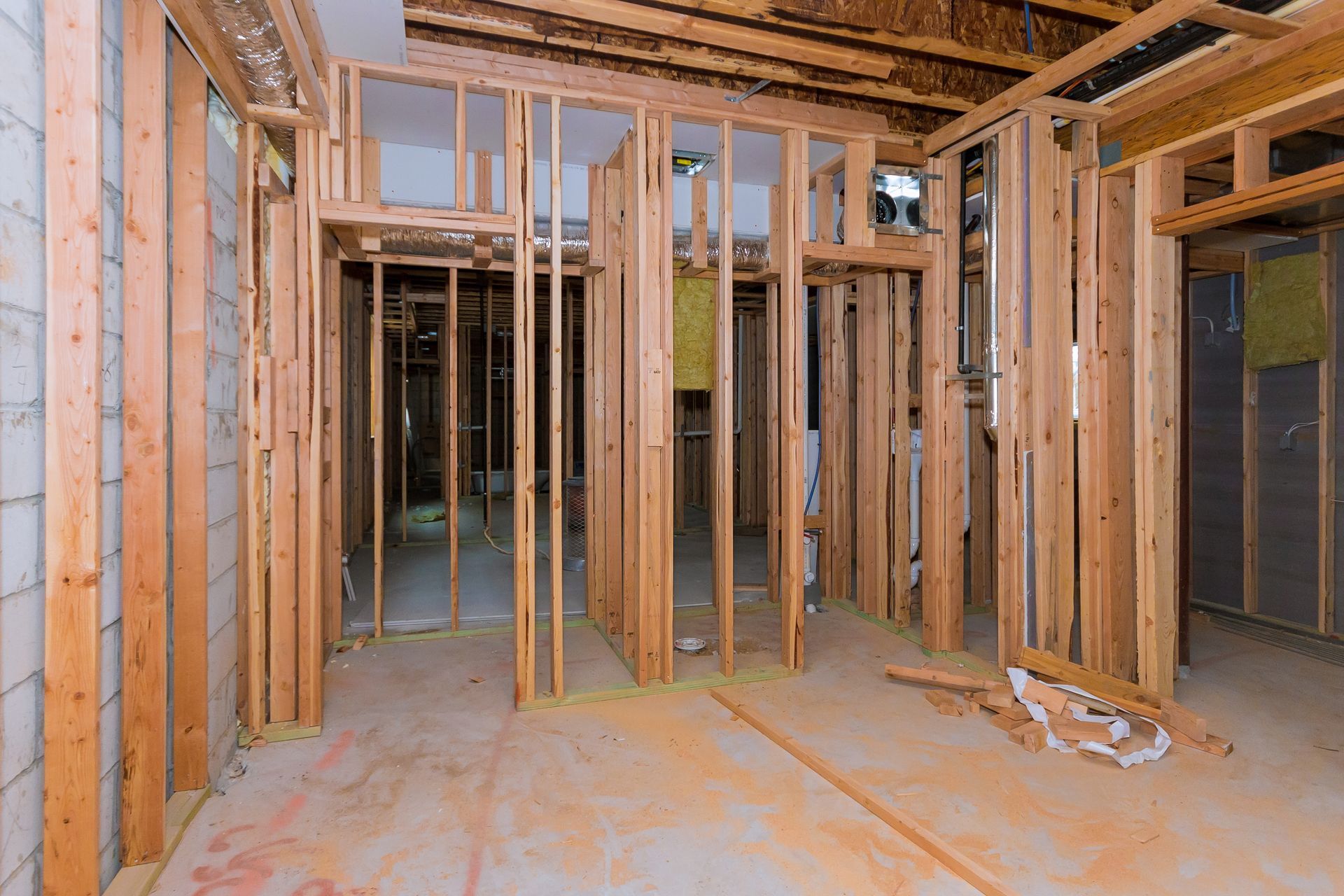 Framed interior of a house under construction with exposed wooden studs and unfinished walls