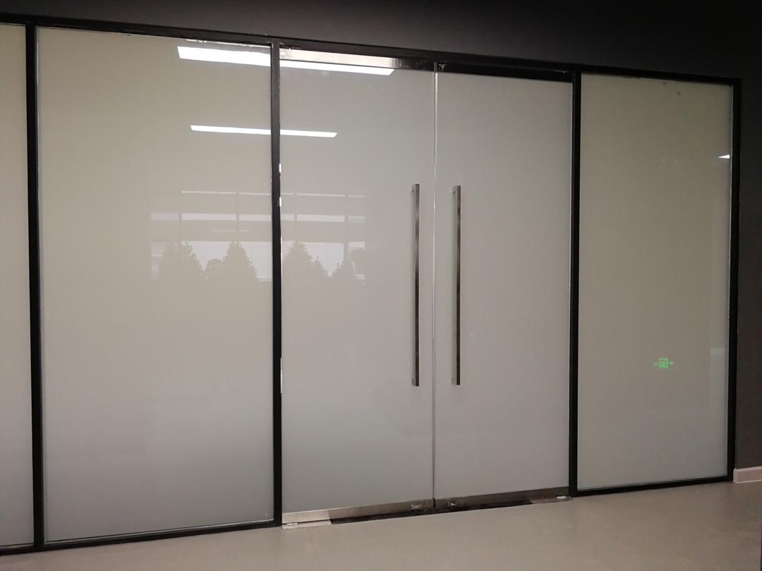 A room with a lot of glass doors and a black frame.
