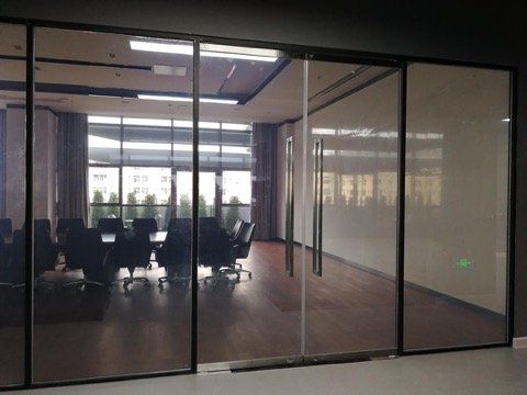 A conference room with sliding glass doors and a table and chairs