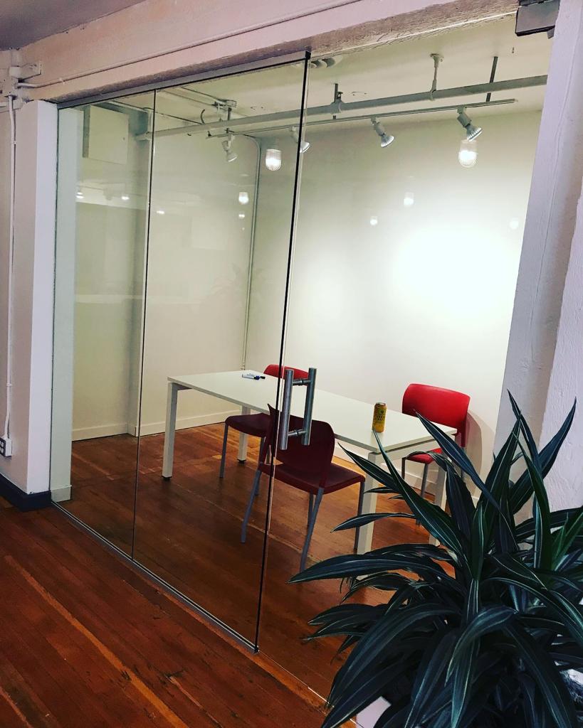 A room with a table and chairs behind a glass wall.