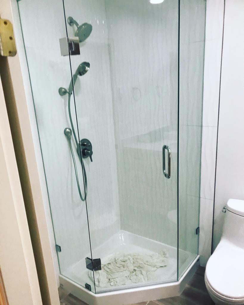 A bathroom with a shower stall and a toilet