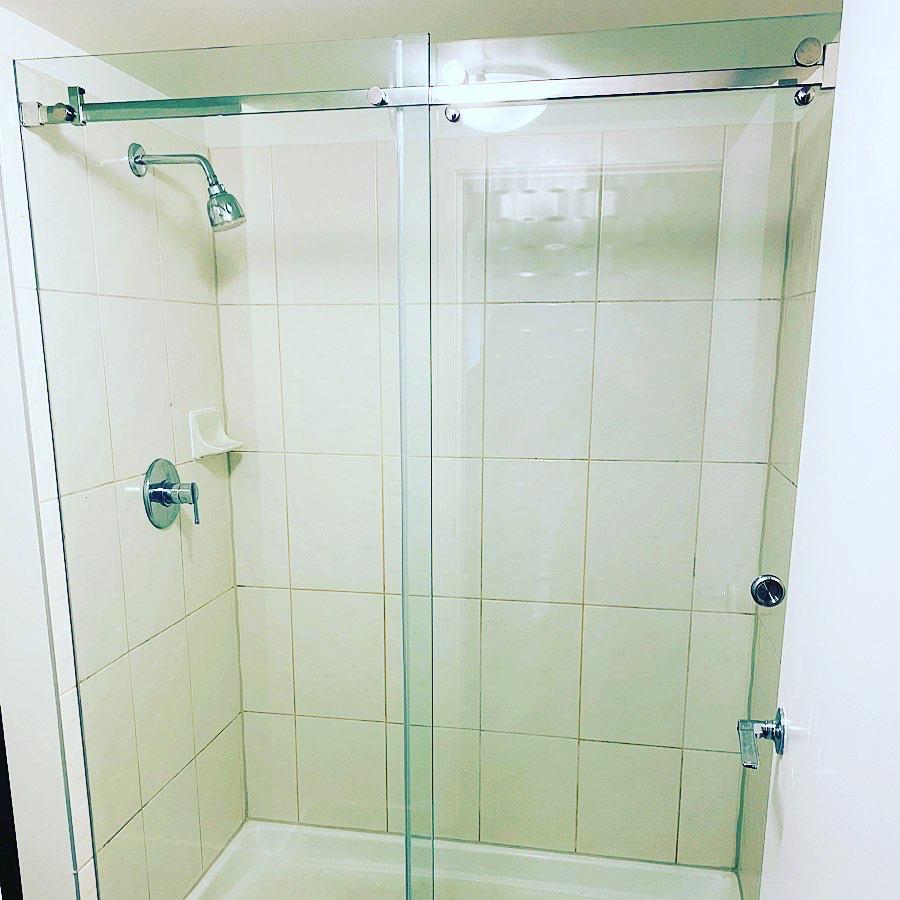 A shower with a sliding glass door and a shower head