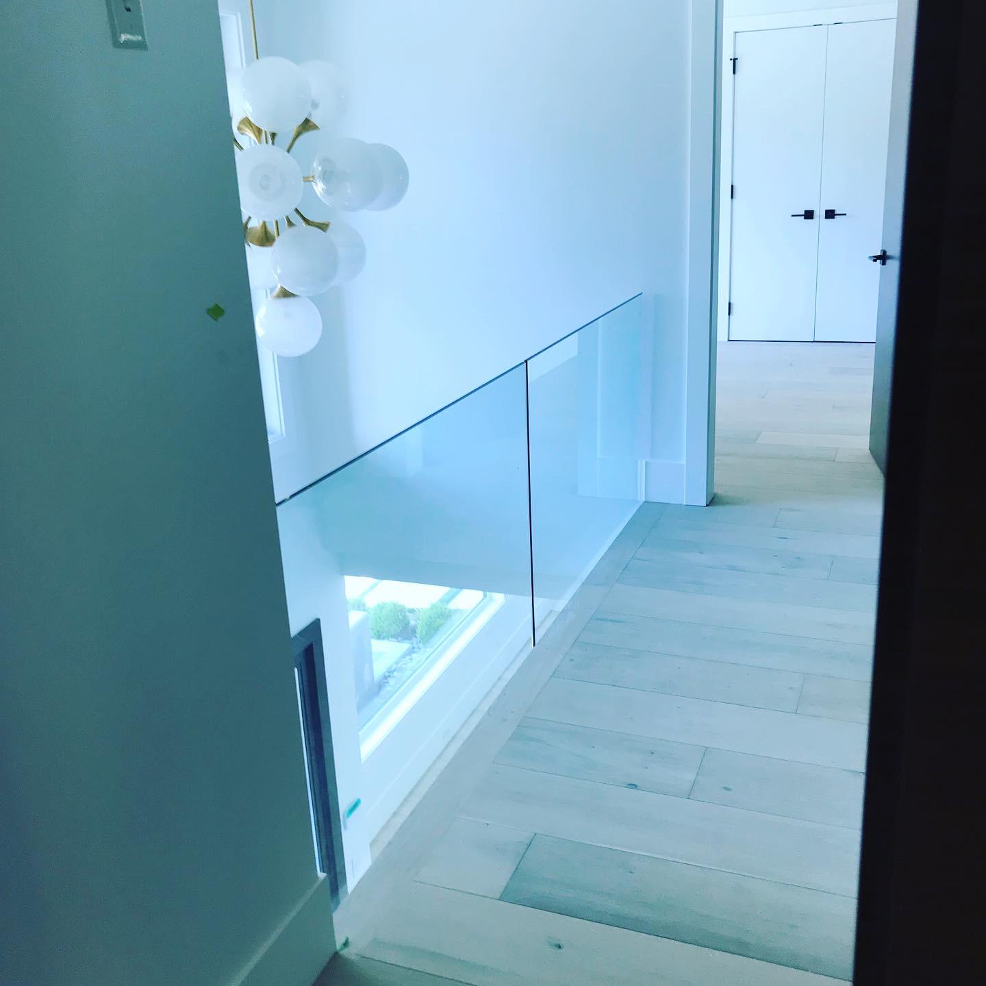 A hallway with a glass railing and a window