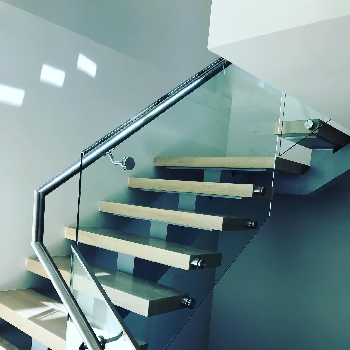 A staircase with a glass railing and wooden steps