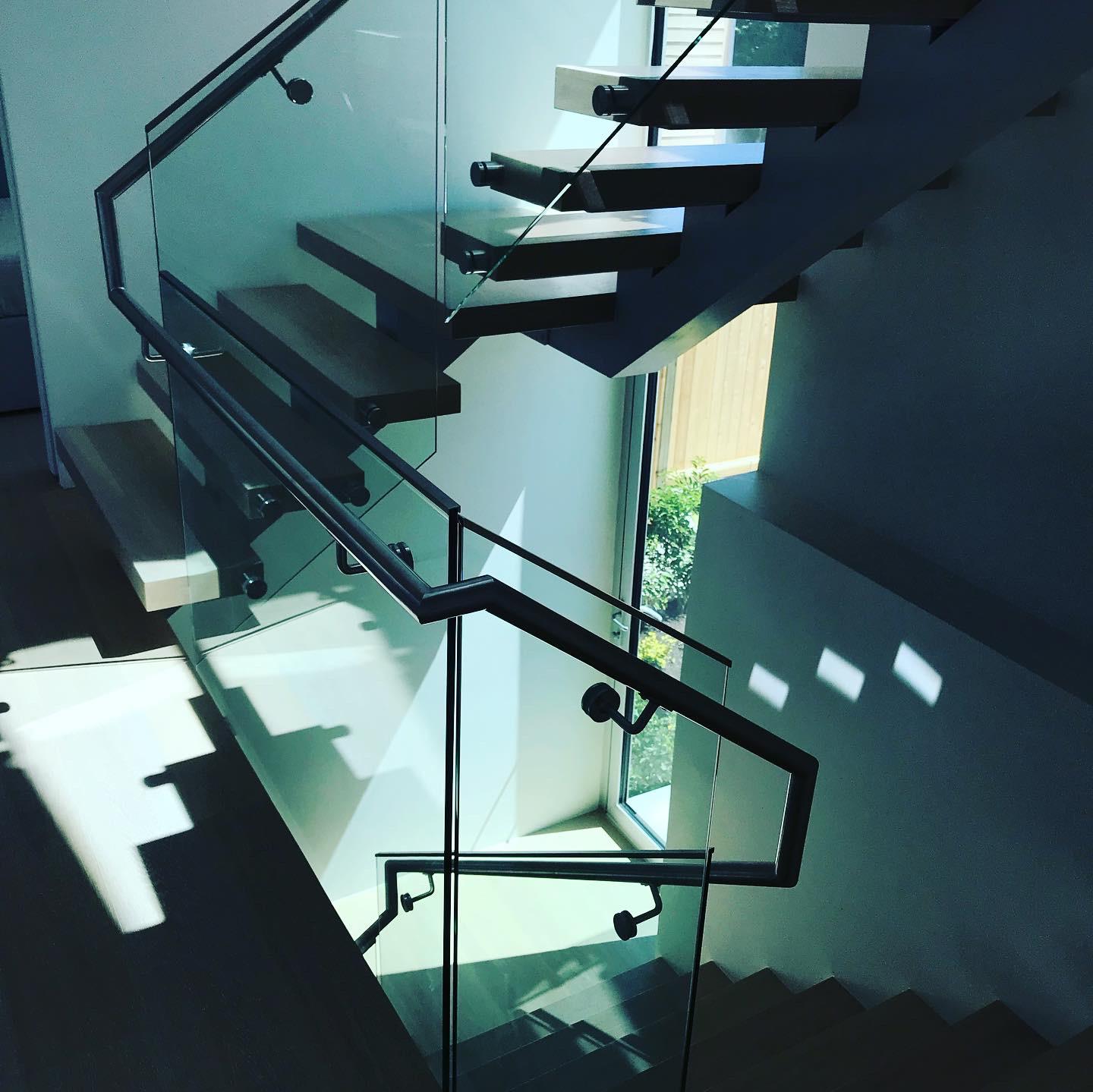 A staircase with a glass railing and wooden steps