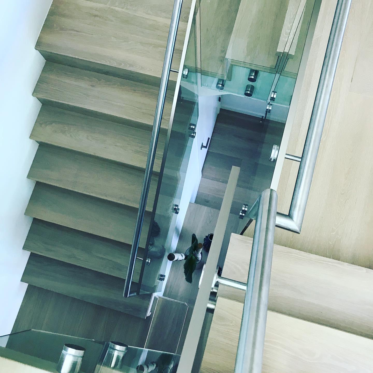 An aerial view of a wooden staircase with a glass railing