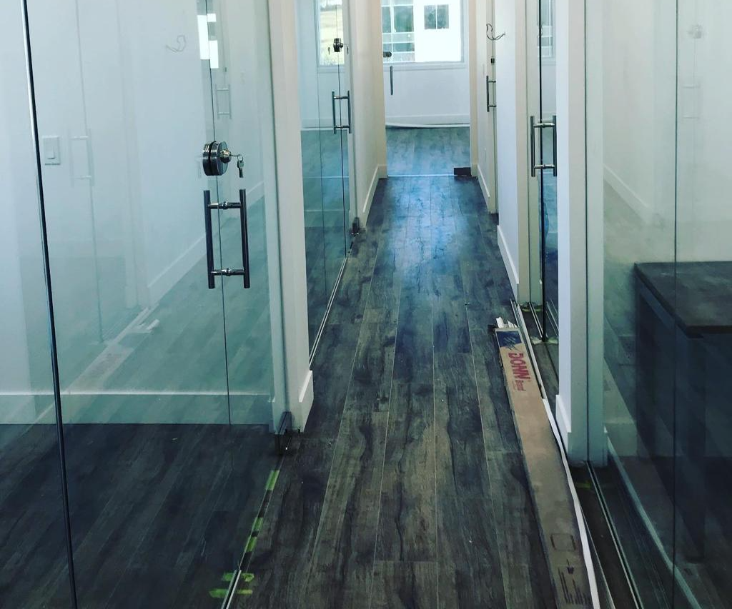 A hallway with hardwood floors and glass doors