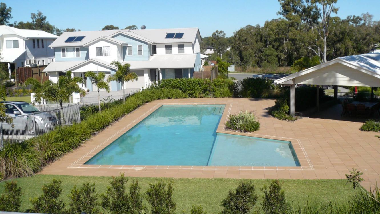 Swimming Pool in a Residential Area with Houses in the Background, Palm Trees — Banora Pools in Murwillumbah, NSW