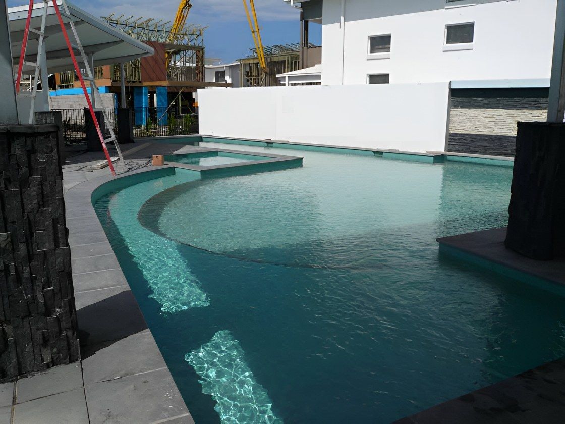 Construction of a Swimming Pool. A Worker in Neon Green Jacket Uses a Tool Inside the Rebar-filled Structure — Banora Pools in Tweed Heads South, NSW