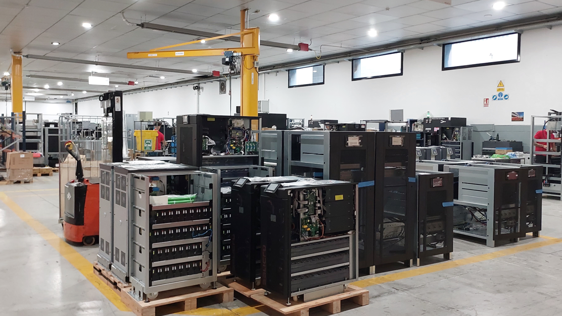Un hombre con máscara y guantes examina los cartuchos de tinta dentro de una máquina.