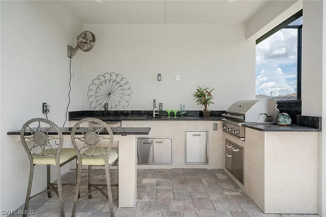 Black and white J shape outdoor kitchen, seating area, grill, storage, Punta Gorda FL