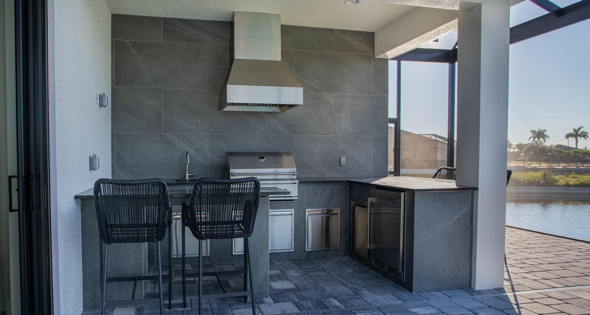 Grey large format tile, J shape outdoor kitchen, delta heat grill, modern, granite countertop , Cape Coral FL