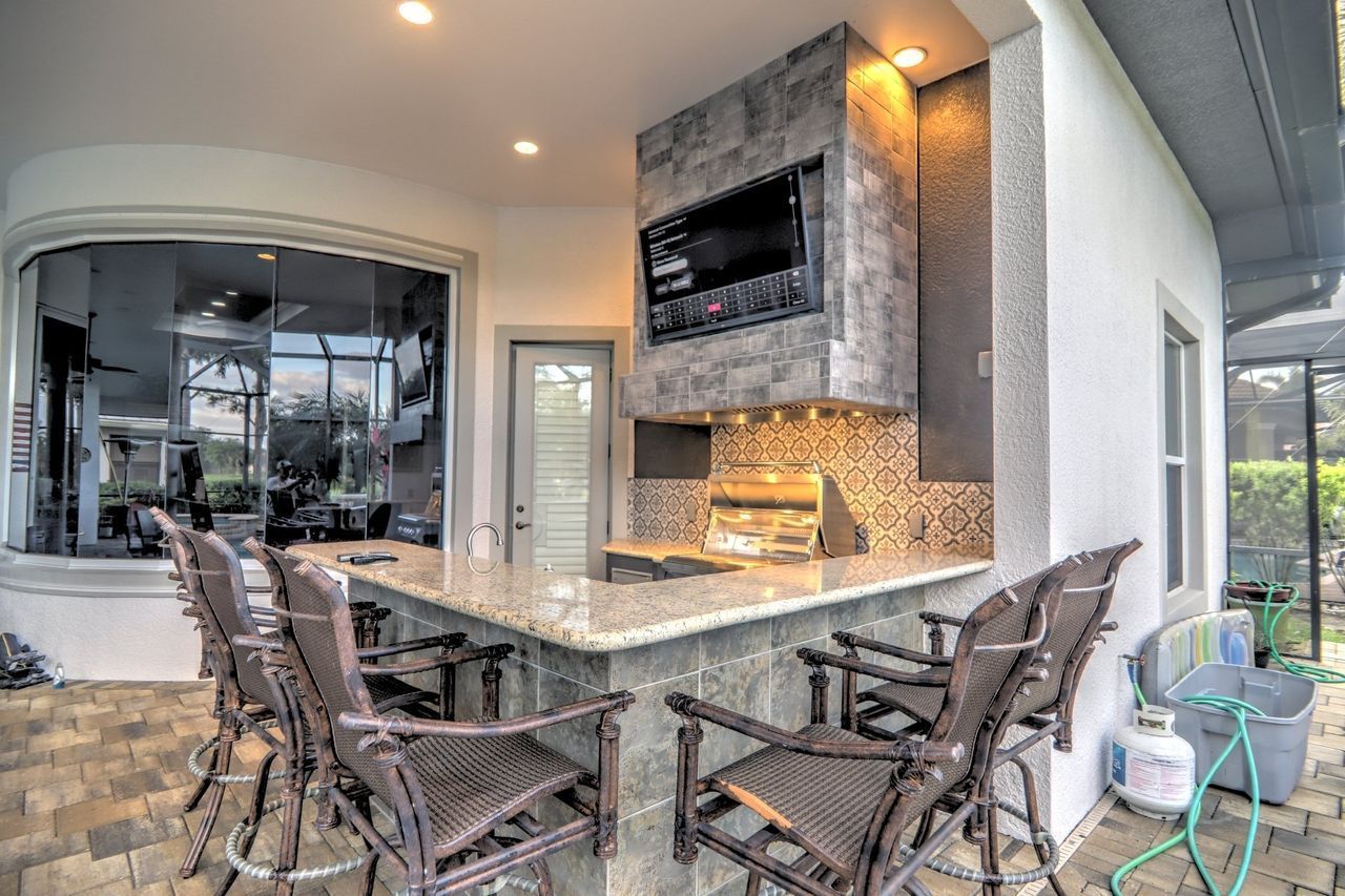 L shape outdoor kitchen, tv build in, bar seating, grey, modern, Fort Myers FL