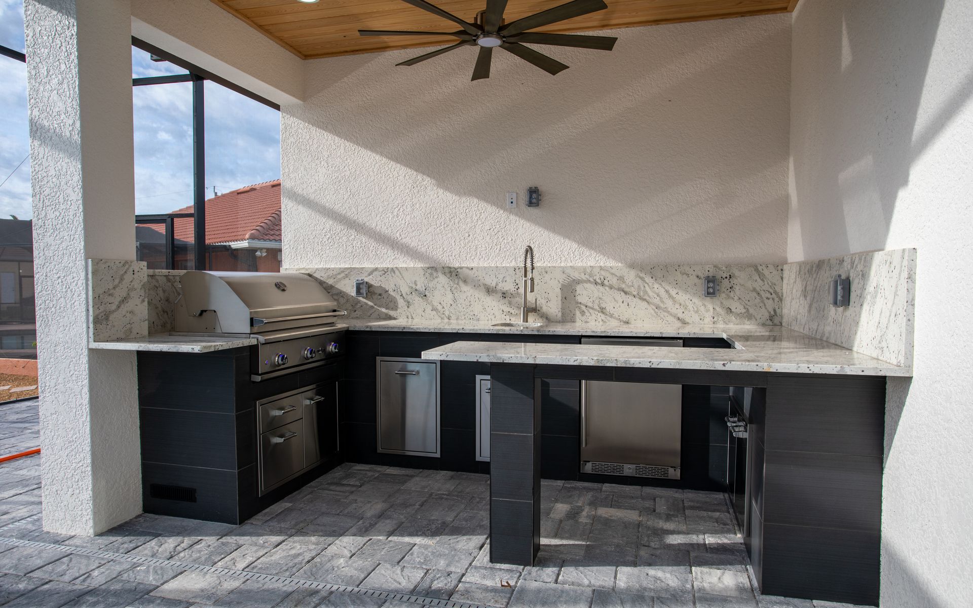 large format black porcelain tile outdoor kitchen white granite countertop stainless steel inserts cape coral, fl