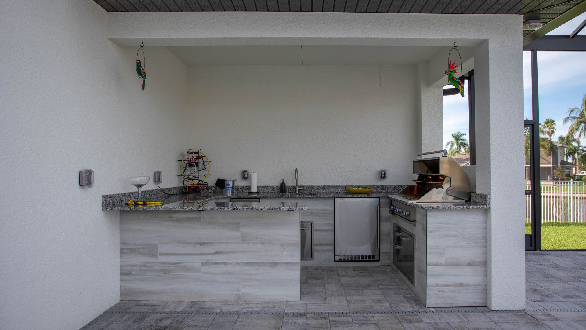 Wood look tile , J shape outdoor kitchen, delta heat grill, granite countertop , Punta Gorda