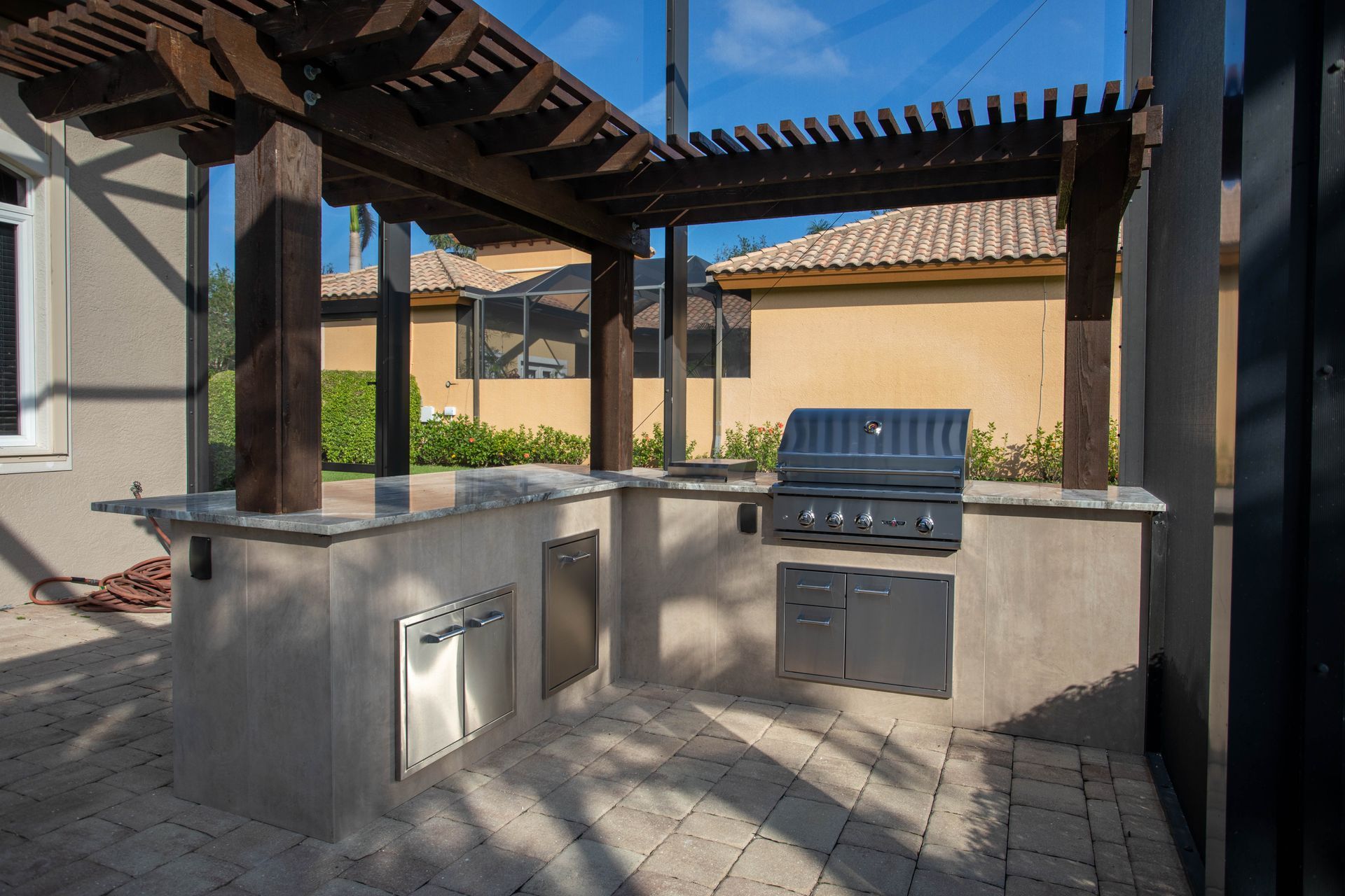 L Shape Outdoor Kitchen under pergola, Granite countertop, freestanding, Delta Heat Inserts Fort Myers FL