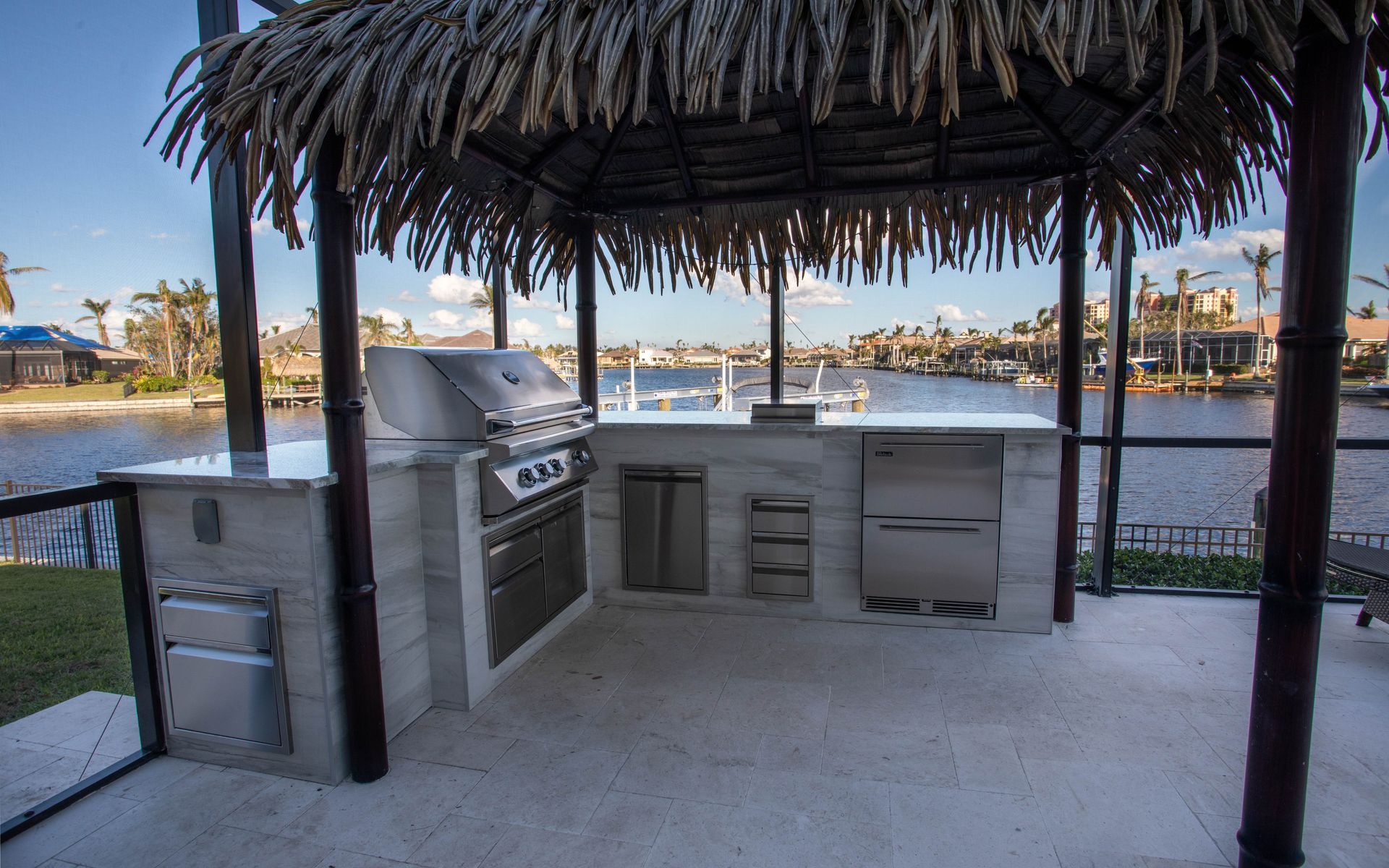 L Shape Outdoor Kitchen under tiki hut, Granite countertop, wood look tile, grey, Valencia Trails FL