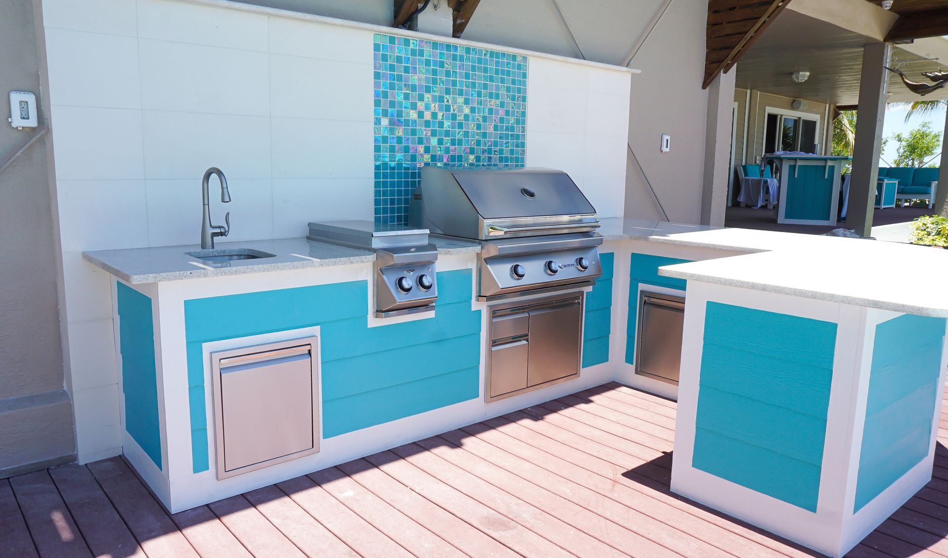 architectural outdoor kitchen bright teal lap siding with quartzite countertops