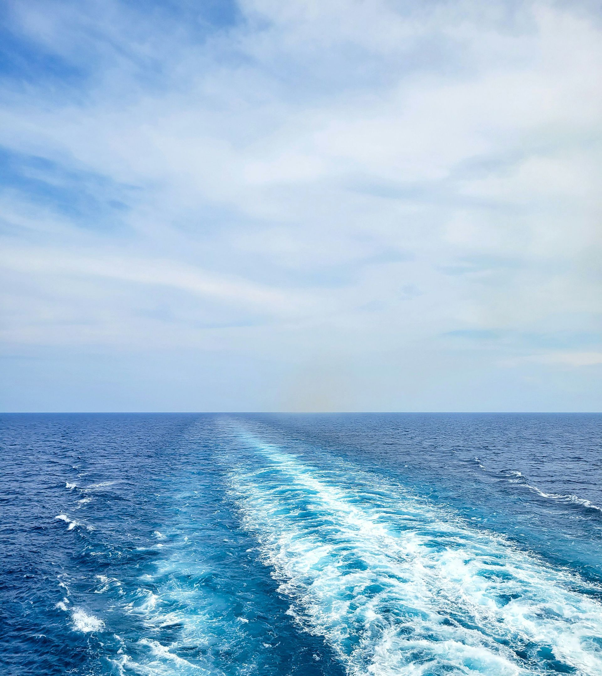 A boat is floating on top of a large body of water.