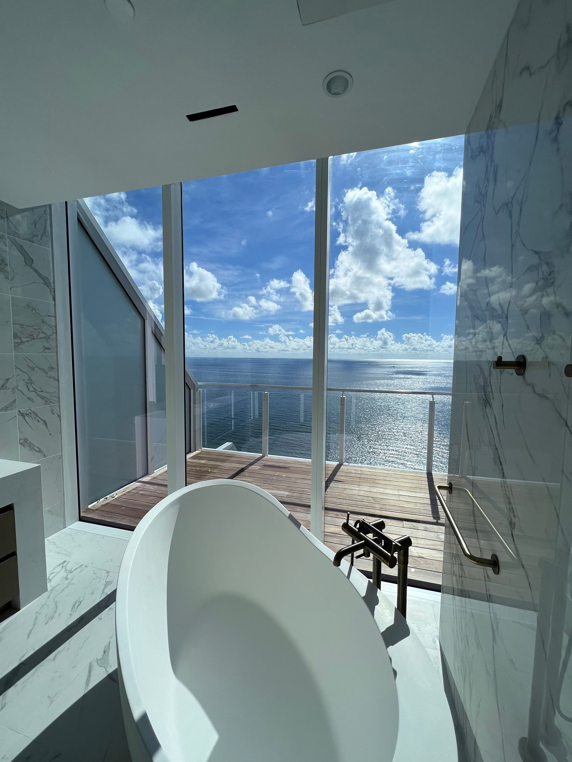 A bathroom with a bathtub and a view of the ocean