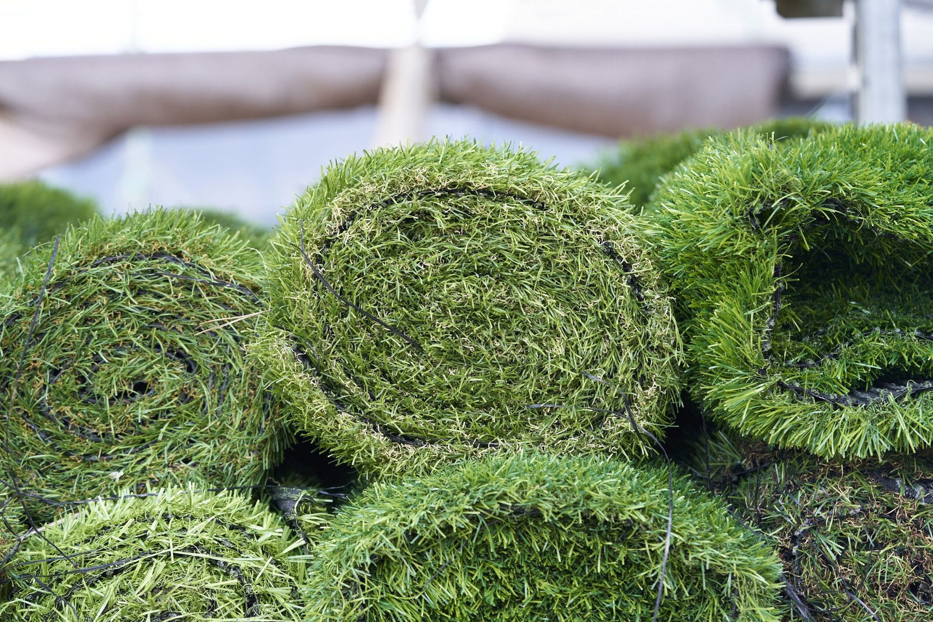 Green rolls of artificial turf stacked on top of each other.