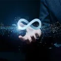 A glowing, light-blue infinity symbol hovers above an open hand against a dark, digital network background.