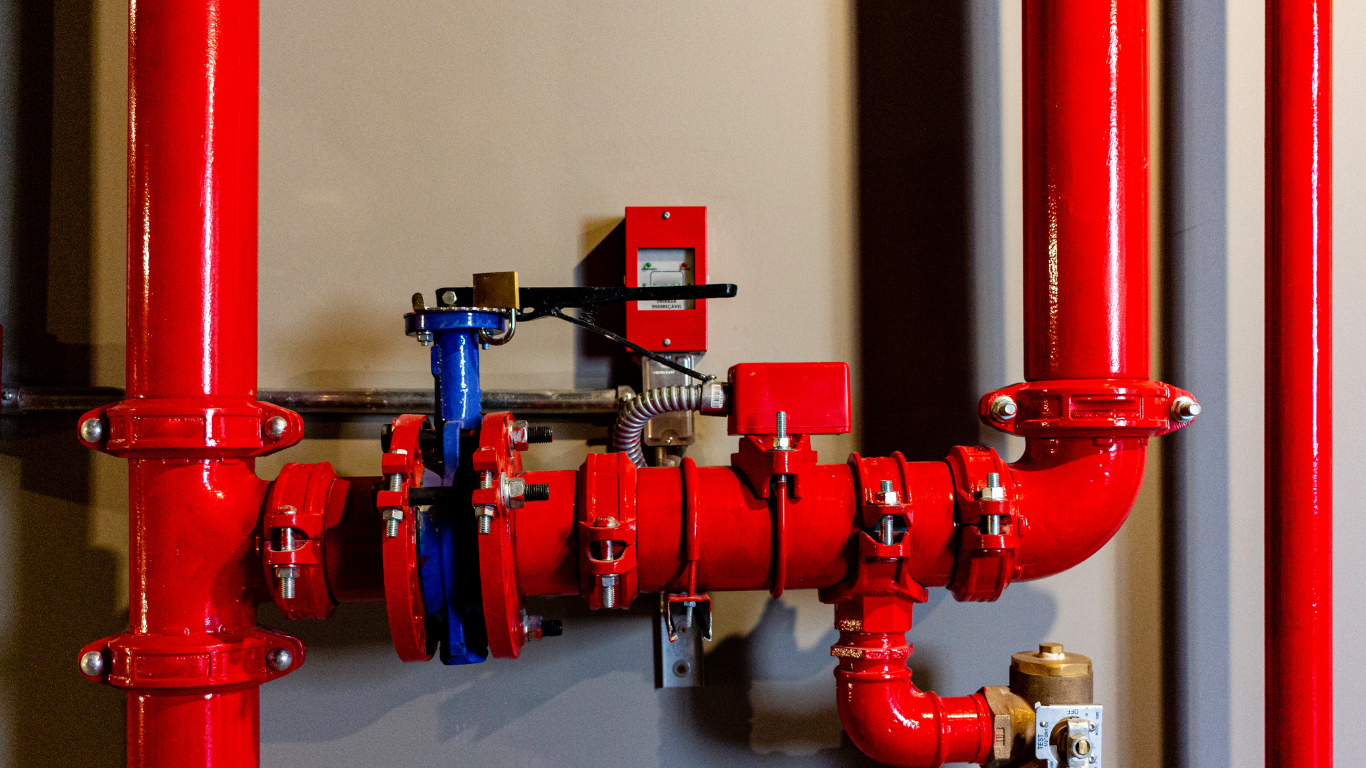 A bunch of red pipes are connected to each other in a room.