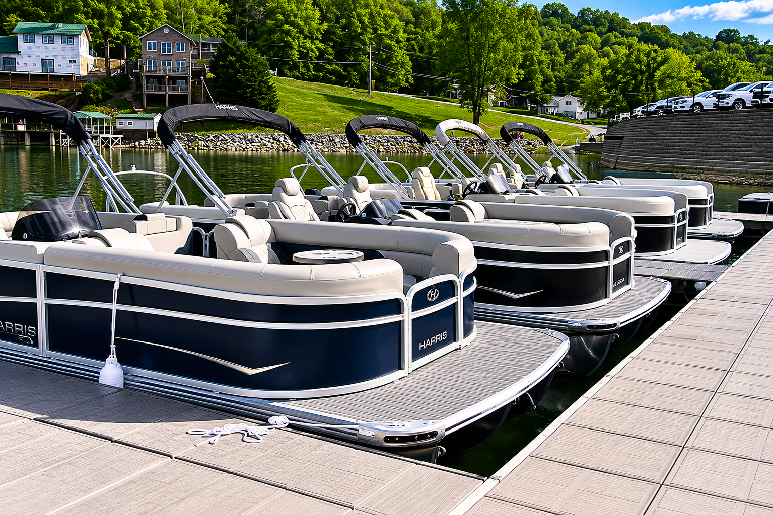 Boats for Sale! Row of black pontoon boats moored at a marina beside a paved dock and green shoreline