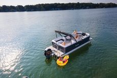 Explore Boat Rentals! Three people in life vests jumping off a pontoon boat into a lake, smiling and splashing water