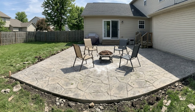Beautiful stamped concrete patio in a backyard with a fire pit
