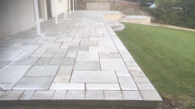 Large slabbed patio and grass area