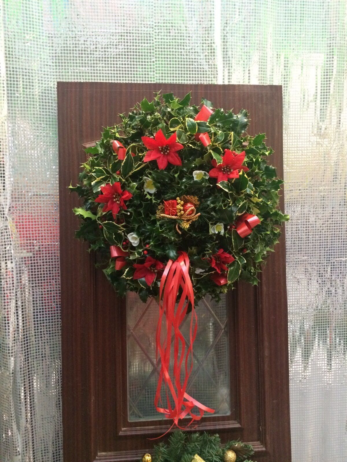 A decorative Christmas wreath with red bows and flowers