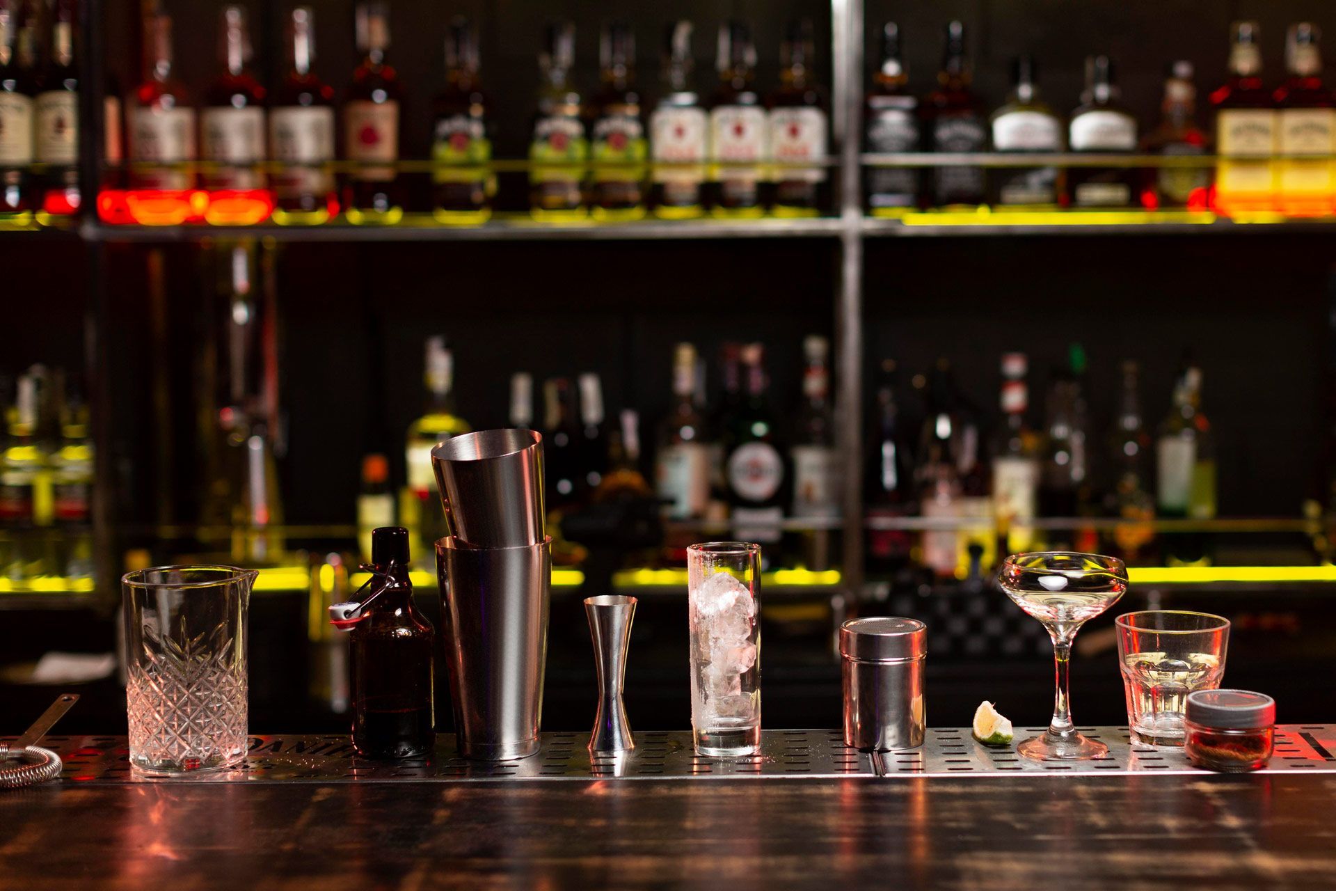 A bar with a lot of bottles and glasses on it.