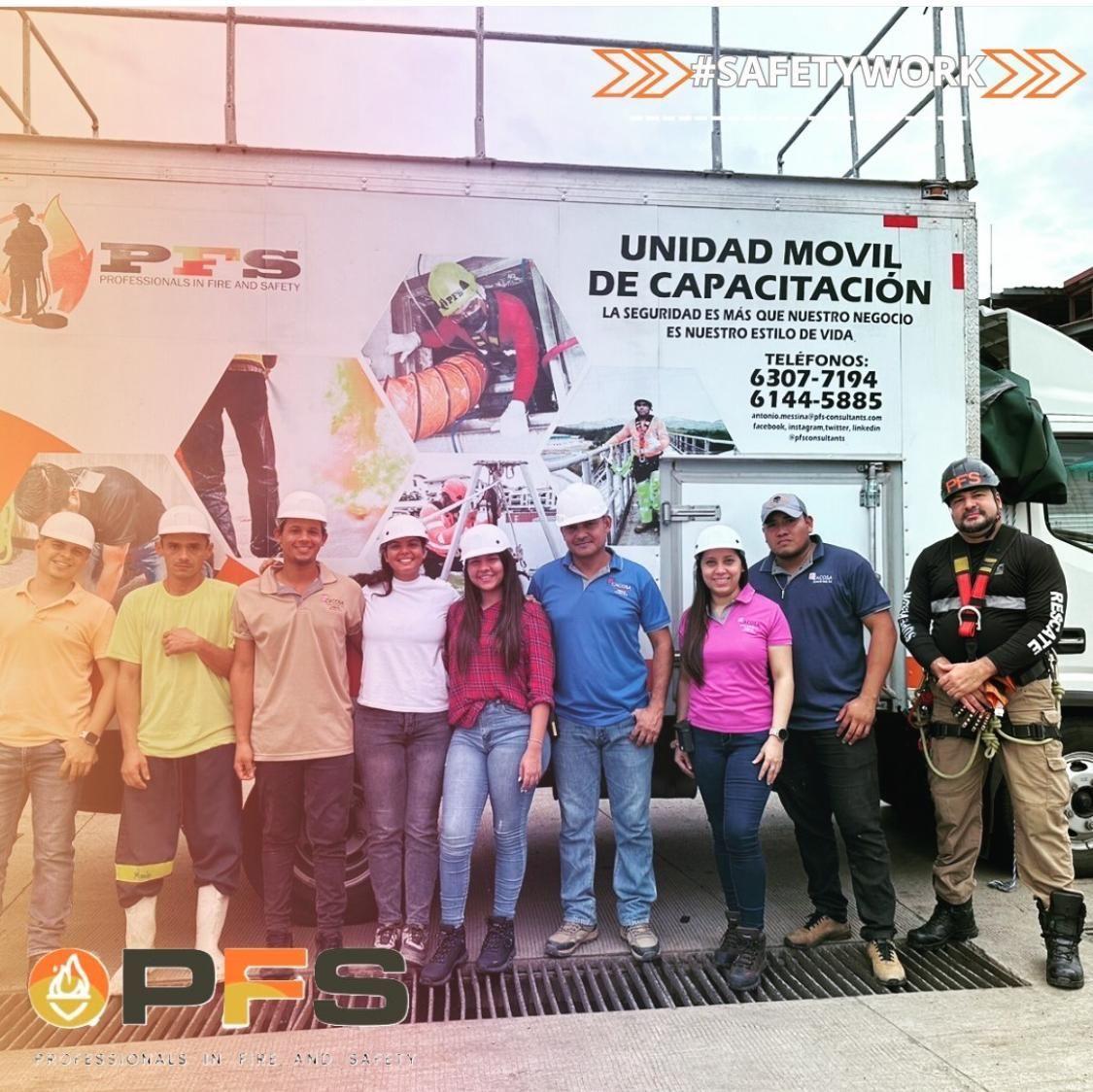 Un grupo de personas con cascos se encuentran frente a un camión de entrenamiento, promoviendo la capacitación en seguridad.
