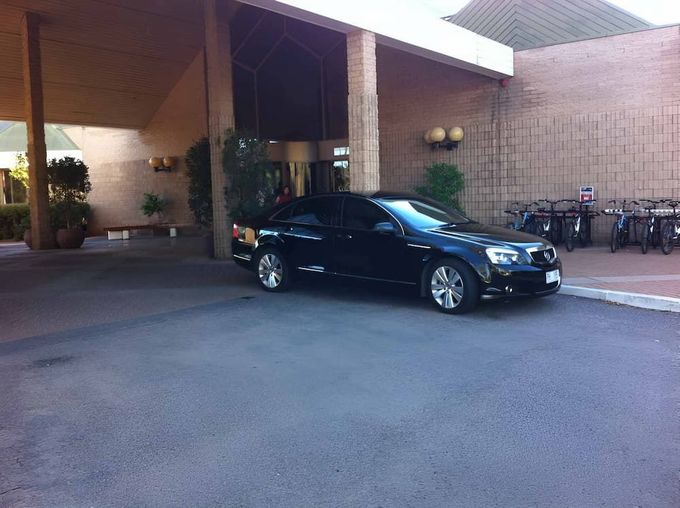 A Black Car Is Parked In Front Of A Building — A & P Private Hire In Sadadeen, NT