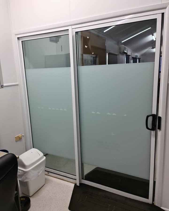 A Room With a Sliding Glass Door and a Trash Can — Ace Tinting In Innisfail, QLD